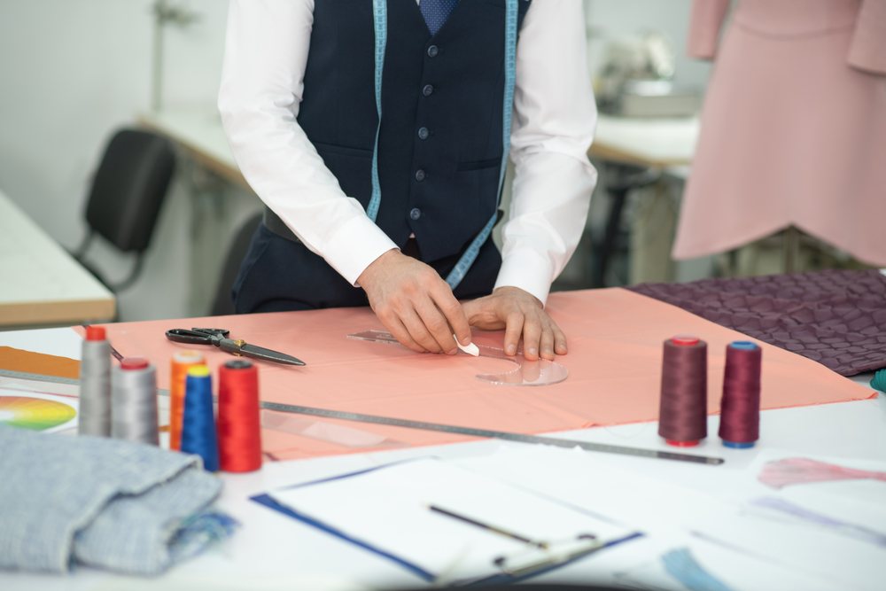 Tailor's hands cutting fabric at Decent Tailor Ahmedabad